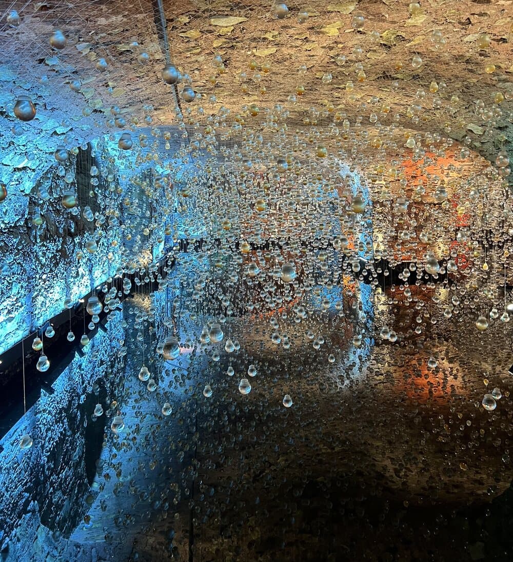 Thousands of clear lightbulbs hanging on wires from the rough stone vault of the Galeria Mercado, lit blue on one side and amber on the other, in the cellars under Salvador's Mercado Modelo