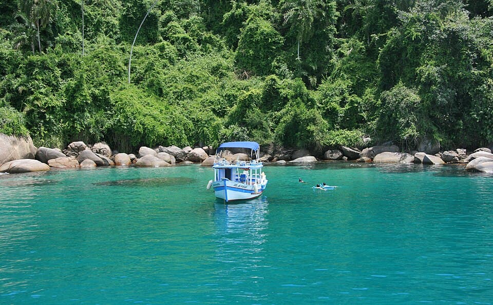 Boat floating in blue water at Lagoa Azul, Ilha Grande