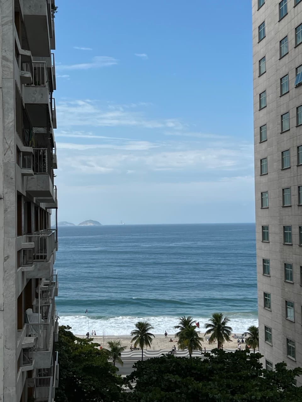 Sea and beach framed between two buildings under a blue sky on a winter day in Copacabana, Rio de Janeiro