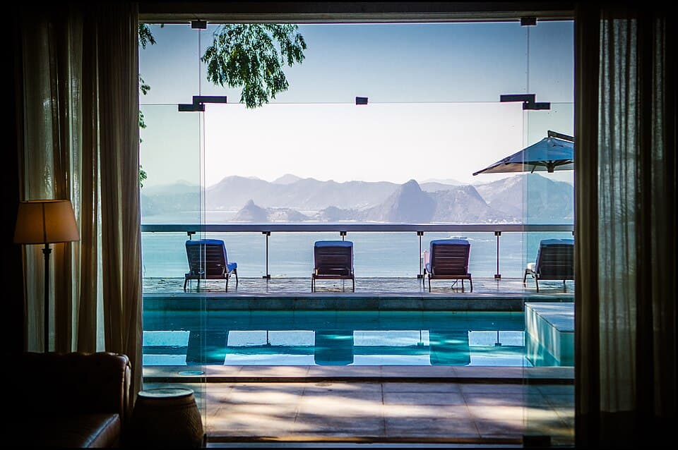 Infinity pool and lounge chairs at Vila Santa Teresa overlooking Guanabara Bay and Sugarloaf Mountain in Rio de Janeiro.
