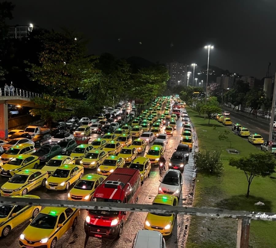 Long line of yellow taxis stuck in traffic at night in Rio de Janeiro.