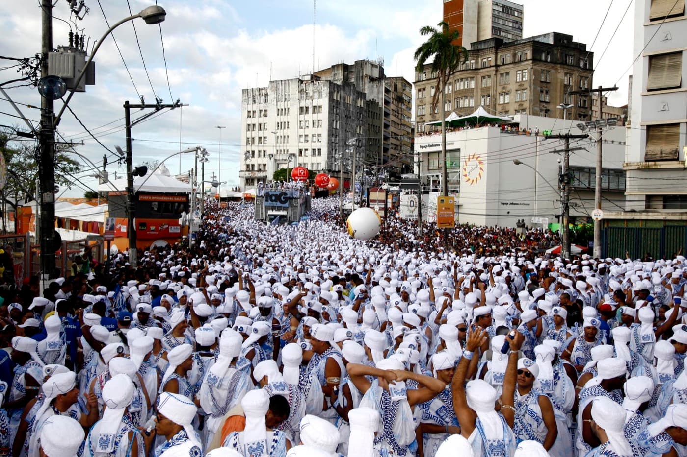 Thousands of Filhos de Gandhy members in white robes and blue-and-white beads filling the street at Campo Grande during the 2010 Carnival in Salvador.