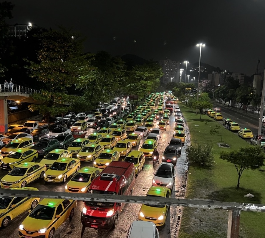 Long line of yellow taxis stuck in traffic at night in Rio de Janeiro.